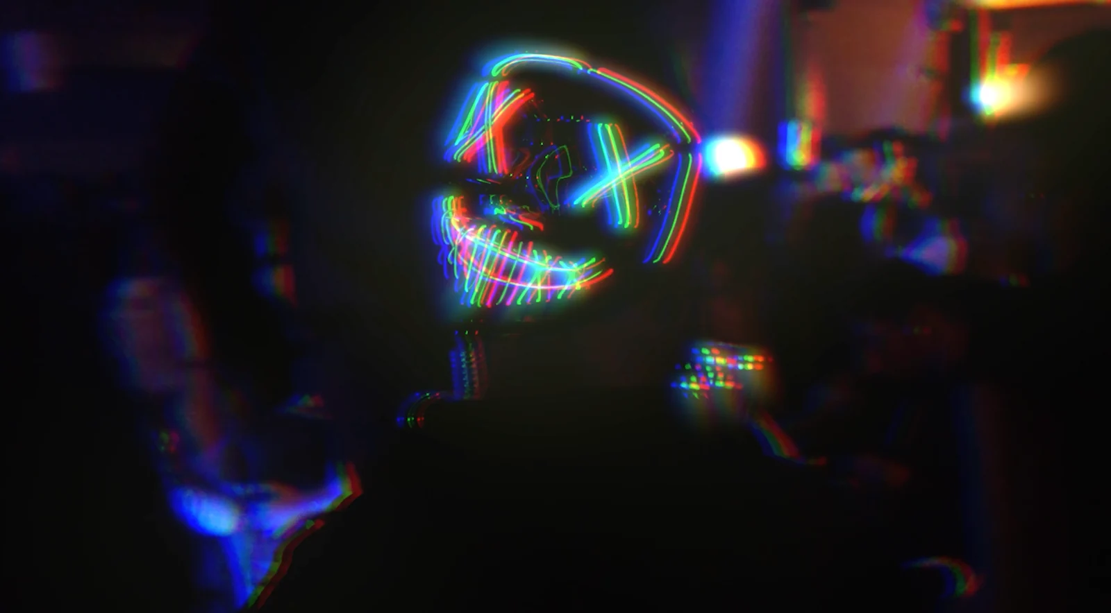 Un masque lumineux multicolore dans une ambiance de soirée.