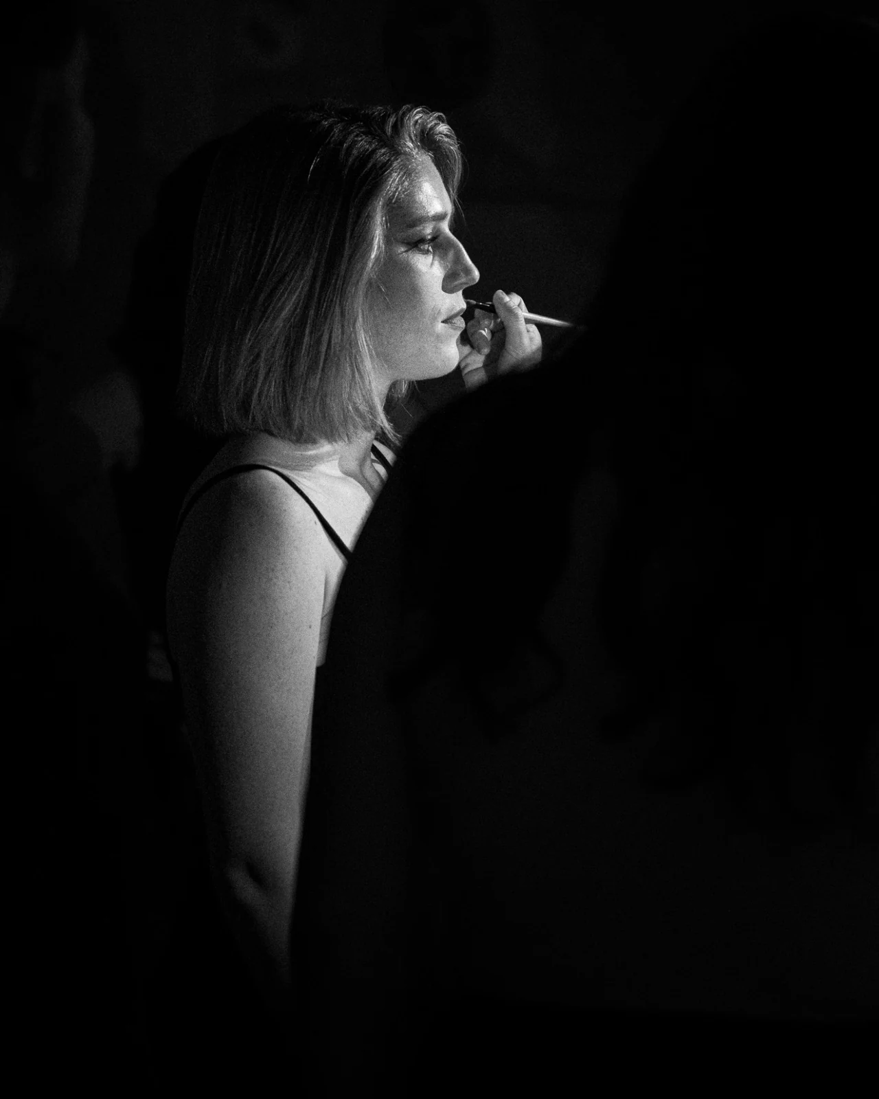 Un portrait de profil pendant une retouche de maquillage, en noir et blanc.