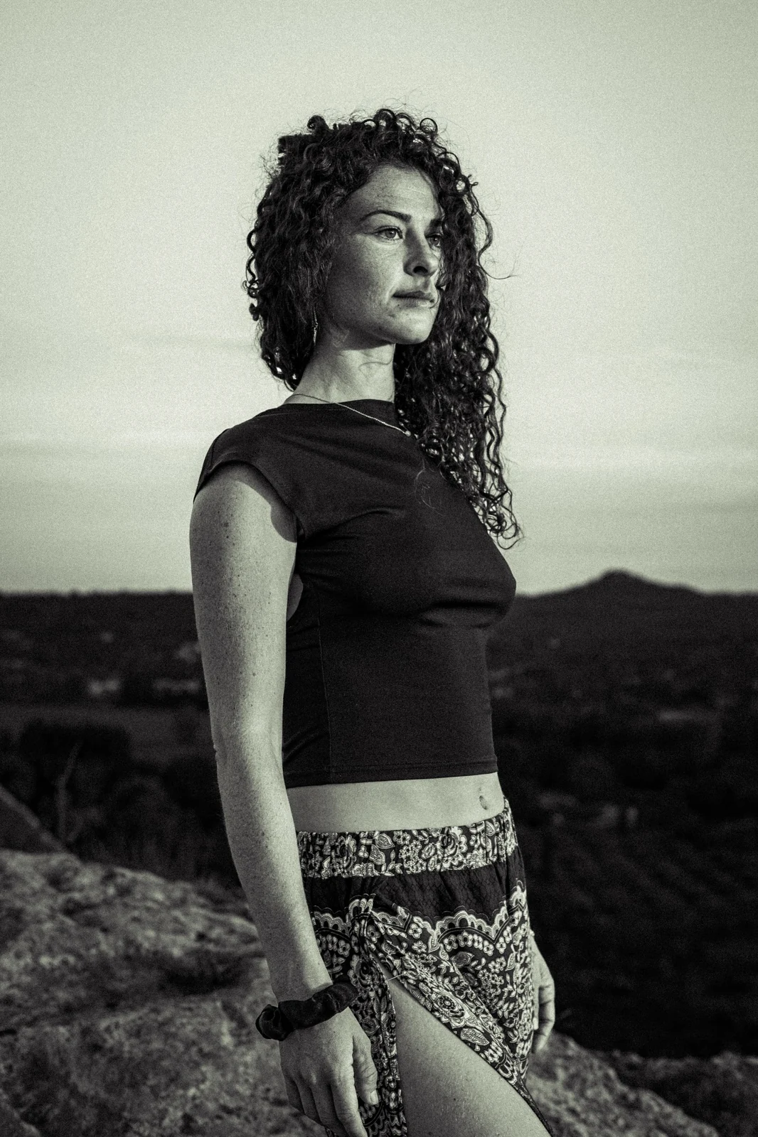 Portrait en extérieur devant un paysage de collines.